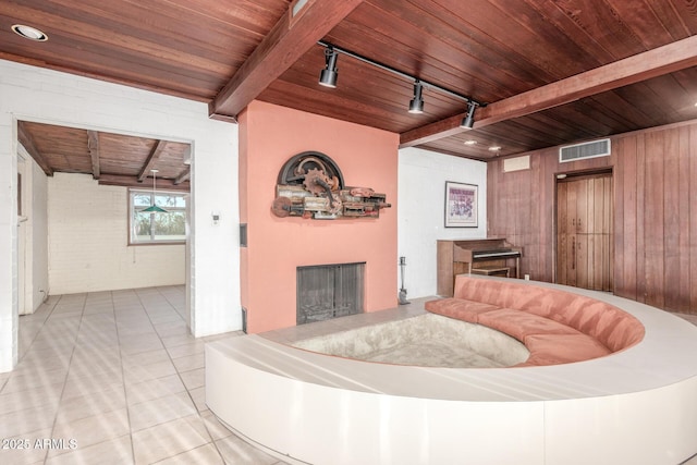 unfurnished living room with wooden ceiling, a fireplace, visible vents, tile patterned floors, and beamed ceiling