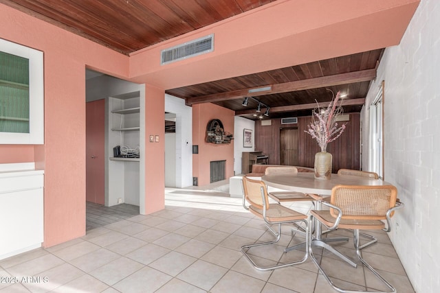 dining area with visible vents, beam ceiling, light tile patterned flooring, and wood ceiling