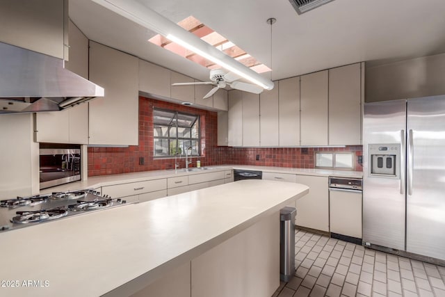 kitchen with tasteful backsplash, extractor fan, stainless steel appliances, light countertops, and a sink