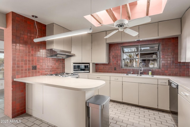 kitchen with stainless steel appliances, light countertops, a sink, and tasteful backsplash