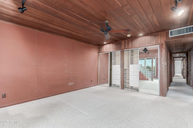 carpeted spare room with wooden ceiling, wooden walls, recessed lighting, visible vents, and a ceiling fan