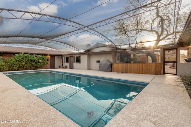 outdoor pool with a patio area and grilling area