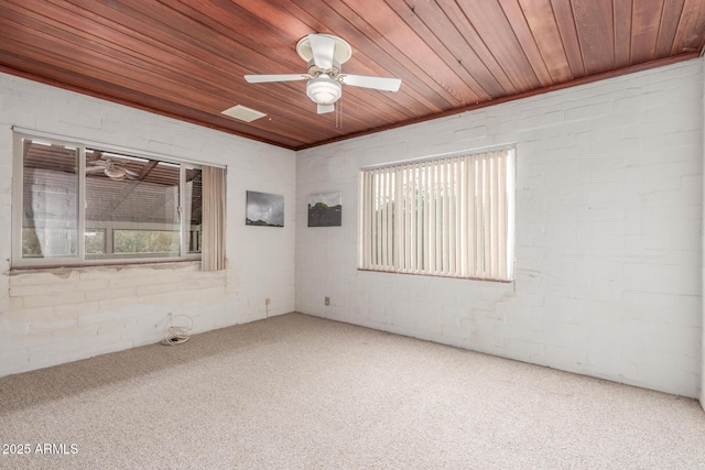 carpeted empty room with a ceiling fan, wooden ceiling, and plenty of natural light