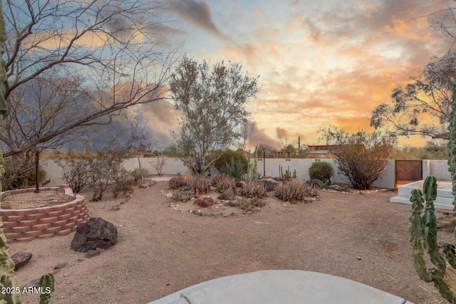 yard at dusk with a fenced backyard