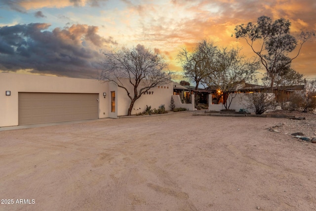 adobe home featuring an attached garage and stucco siding