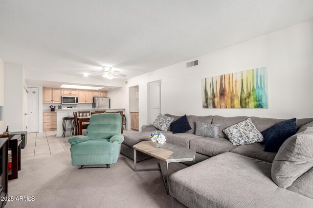 living room featuring light colored carpet and ceiling fan