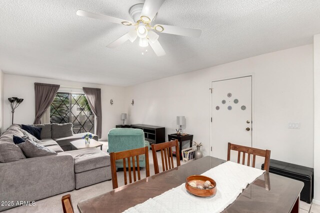 dining area with ceiling fan and a textured ceiling