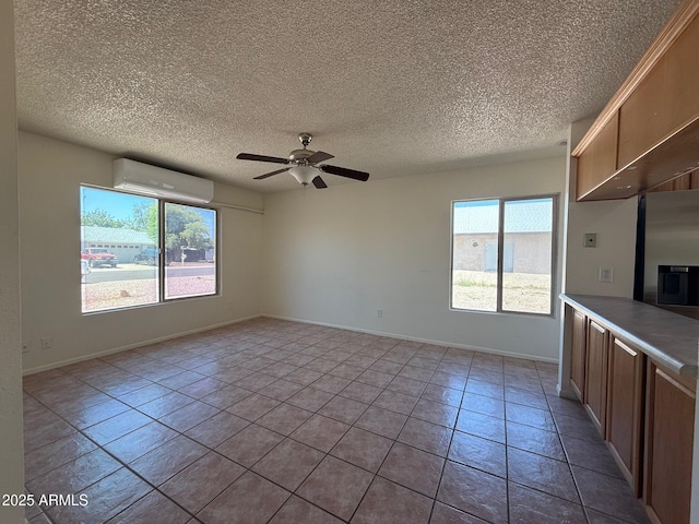 5634 W Puget Ave, Glendale, AZ 85302 - unfurnished living room with an AC wall unit, a ceiling fan, tile patterned flooring, and a textured ceiling
