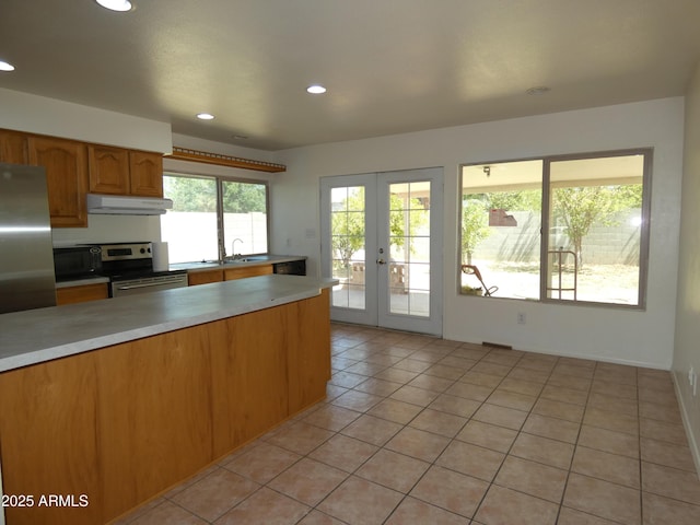 5634 W Puget Ave, Glendale, AZ 85302 - kitchen featuring stainless steel appliances, under cabinet range hood, light countertops, french doors, and light tile patterned floors