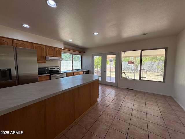 5634 W Puget Ave, Glendale, AZ 85302 - kitchen featuring appliances with stainless steel finishes, recessed lighting, light tile patterned floors, light countertops, and under cabinet range hood