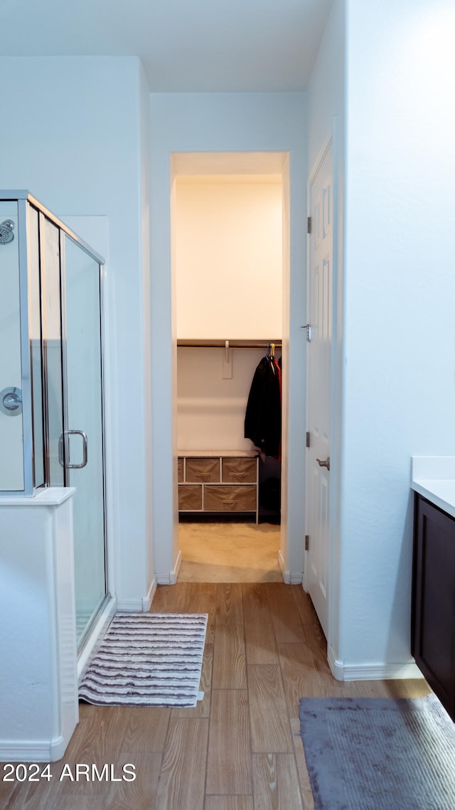 bathroom featuring vanity, wood-type flooring, and walk in shower