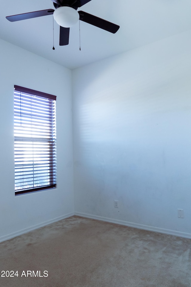 carpeted spare room with ceiling fan