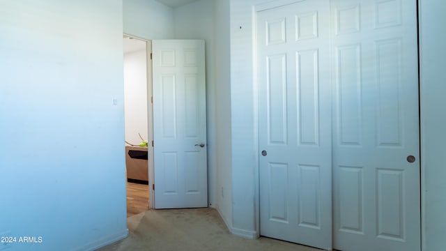 unfurnished bedroom featuring a closet and light colored carpet