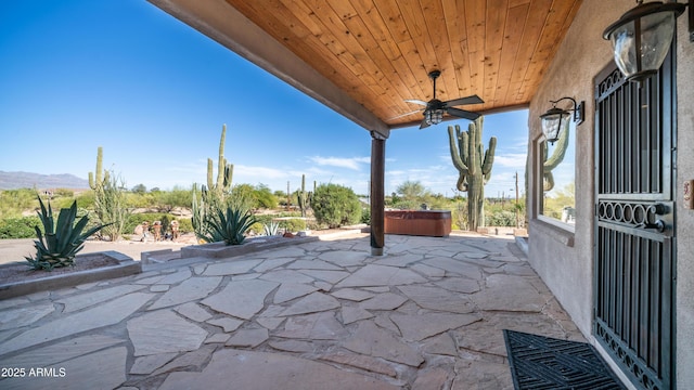 view of patio featuring a ceiling fan and a hot tub