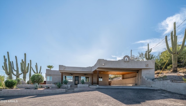 view of front facade with a ceiling fan and stucco siding