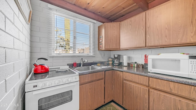 kitchen featuring white appliances, wood ceiling, and a sink