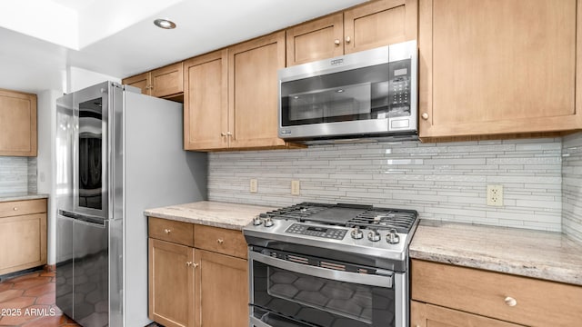 kitchen with stainless steel appliances, tile patterned floors, light stone counters, and tasteful backsplash