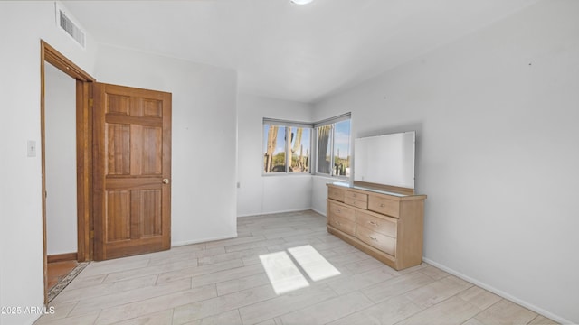unfurnished bedroom featuring baseboards, visible vents, and light wood-type flooring