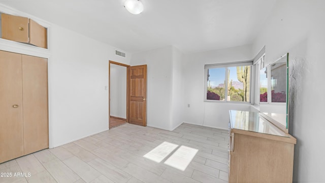 unfurnished bedroom featuring visible vents and a closet