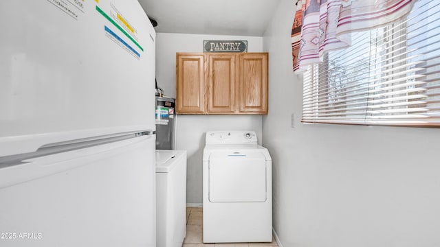 laundry room with cabinet space, light tile patterned floors, baseboards, water heater, and separate washer and dryer