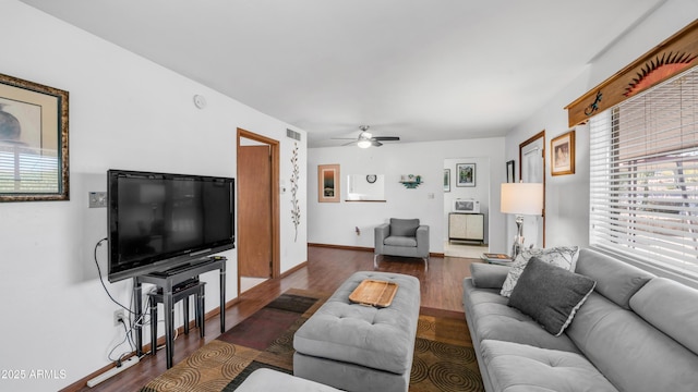 living room featuring baseboards, ceiling fan, and wood finished floors