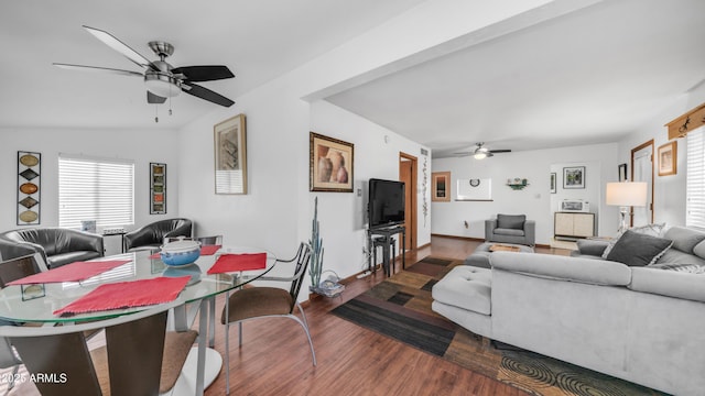 living area featuring a ceiling fan, baseboards, and wood finished floors