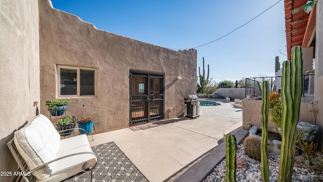 view of patio featuring fence, a fenced in pool, and a grill