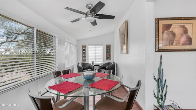 dining space with a ceiling fan and vaulted ceiling