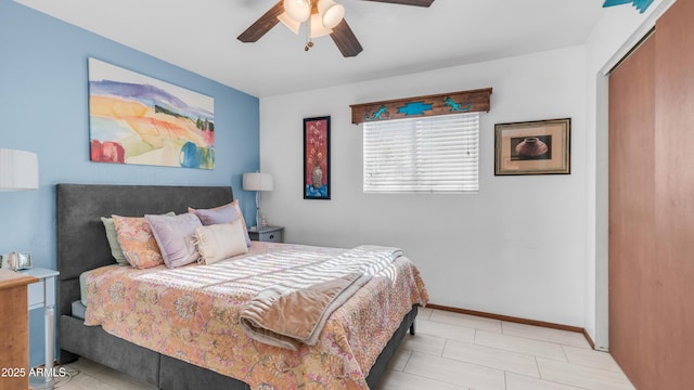 bedroom with baseboards, ceiling fan, tile patterned flooring, and a closet