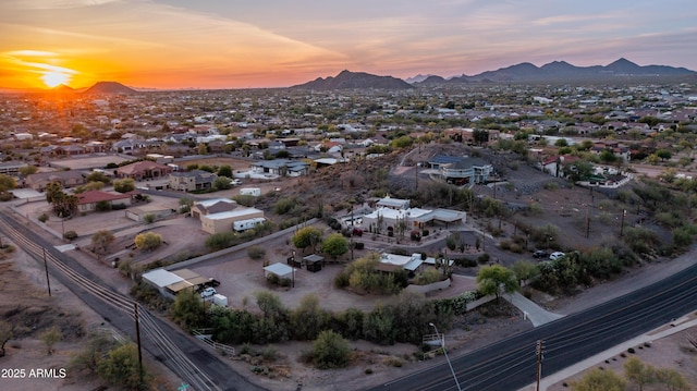 aerial view at dusk featuring a residential view and a mountain view