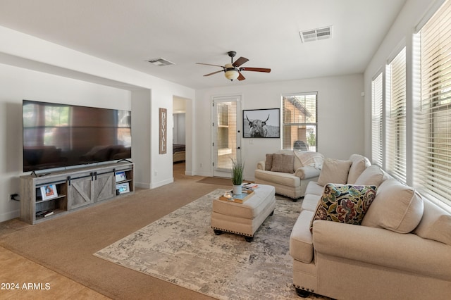 carpeted living room with ceiling fan and a healthy amount of sunlight