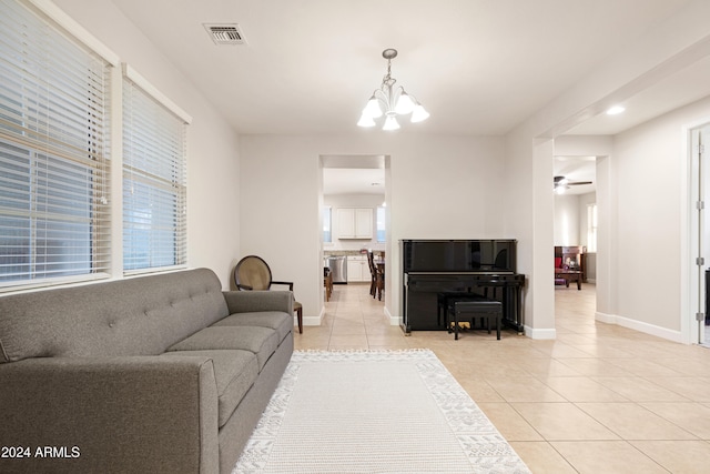 tiled living room featuring ceiling fan with notable chandelier