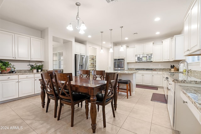 dining space featuring sink, an inviting chandelier, and light tile patterned floors