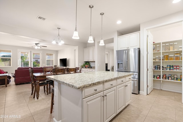 kitchen featuring a center island, stainless steel fridge with ice dispenser, pendant lighting, white cabinetry, and ceiling fan with notable chandelier