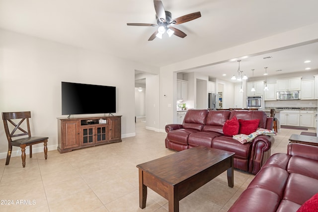 living room featuring ceiling fan with notable chandelier and light tile patterned floors