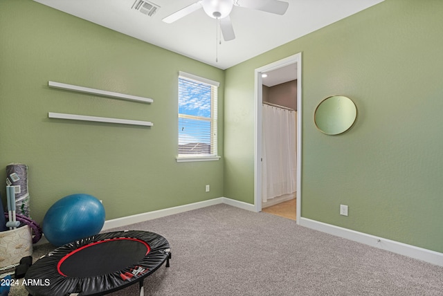 exercise area with ceiling fan and light colored carpet