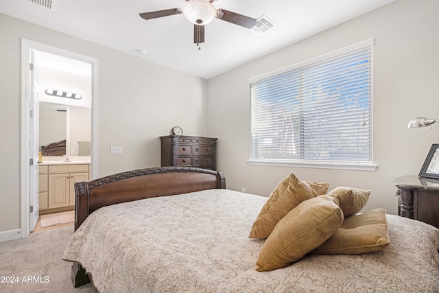 bedroom with light colored carpet, connected bathroom, sink, and ceiling fan