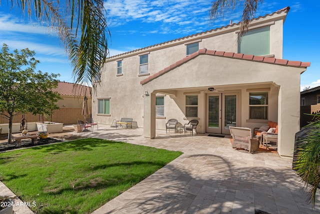 rear view of property with a patio, french doors, ceiling fan, outdoor lounge area, and a lawn