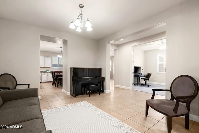 tiled living room featuring ceiling fan with notable chandelier