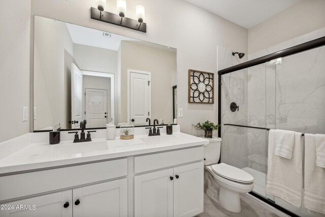 bathroom with vanity, a shower with shower door, and toilet