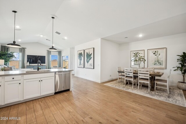 kitchen with dishwasher, white cabinetry, hanging light fixtures, sink, and lofted ceiling