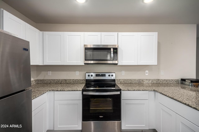 kitchen with light stone countertops, white cabinetry, stainless steel appliances, and recessed lighting