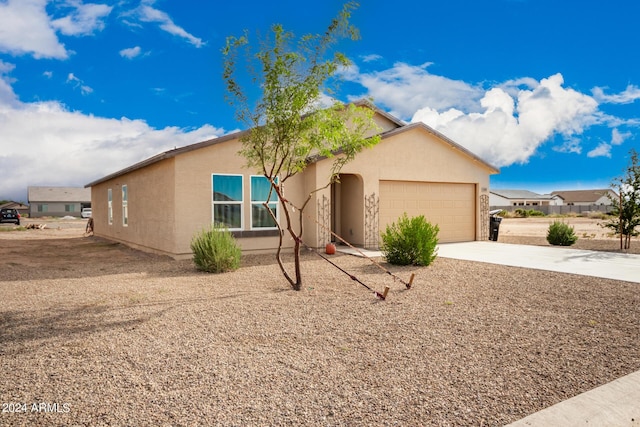 ranch-style home with a garage, concrete driveway, and stucco siding