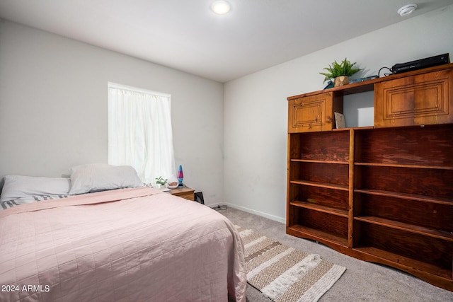 bedroom with baseboards and light colored carpet