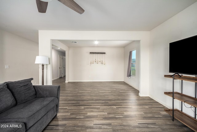 living room with a ceiling fan, visible vents, baseboards, and wood finished floors