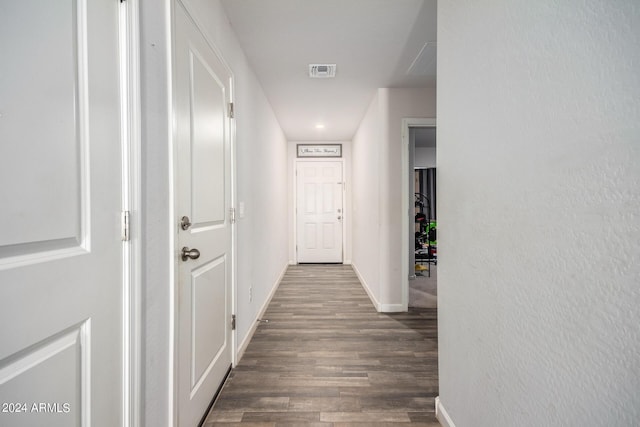 corridor with baseboards, visible vents, and dark wood-style flooring