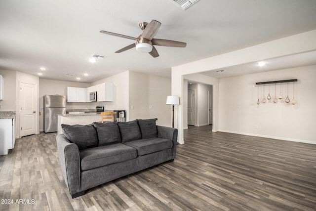 living area featuring baseboards, visible vents, ceiling fan, and dark wood-type flooring