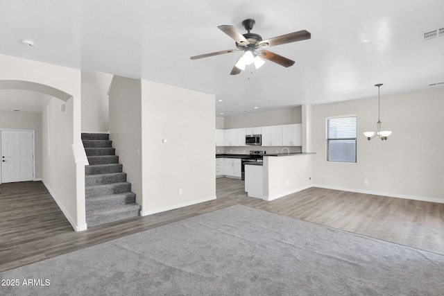 unfurnished living room with ceiling fan with notable chandelier, dark hardwood / wood-style floors, and sink