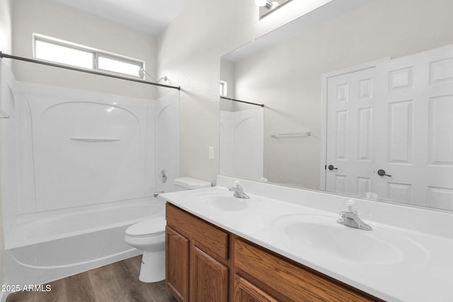 full bathroom featuring shower / washtub combination, wood-type flooring, vanity, and toilet