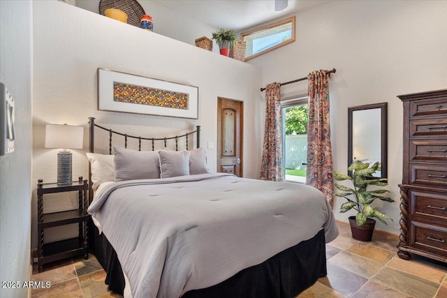 8514 E Country Club Trl, Scottsdale, AZ 85255 - bedroom featuring stone tile floors, a towering ceiling, and baseboards